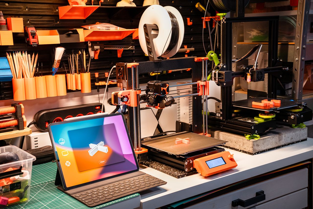 gallery-3 A high-tech workshop featuring 3D printers and a tablet on a desk, showcasing modern innovation.